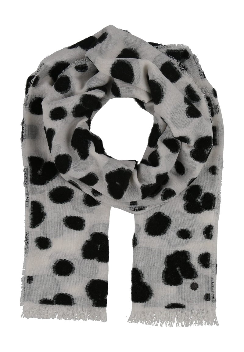 Écharpe gris clair avec des pois noirs irréguliers et des bords à franges, pliée en forme de boucle sur un fond blanc.