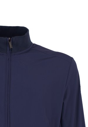 Granatowa kurtka z wysokim kołnierzem, przednim zamkiem błyskawicznym i gładkim materiałem, widoczna od górnej części klatki piersiowej do okolicy ramienia na białym tle.