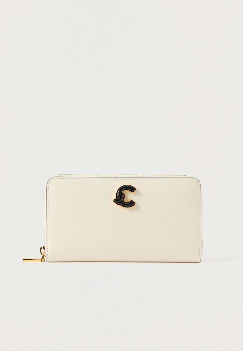 Crème leren portemonnee met een gladde textuur, ritsluiting en een zwart logo accent aan de voorkant. Rechthoekige vorm met subtiele stikdetails.