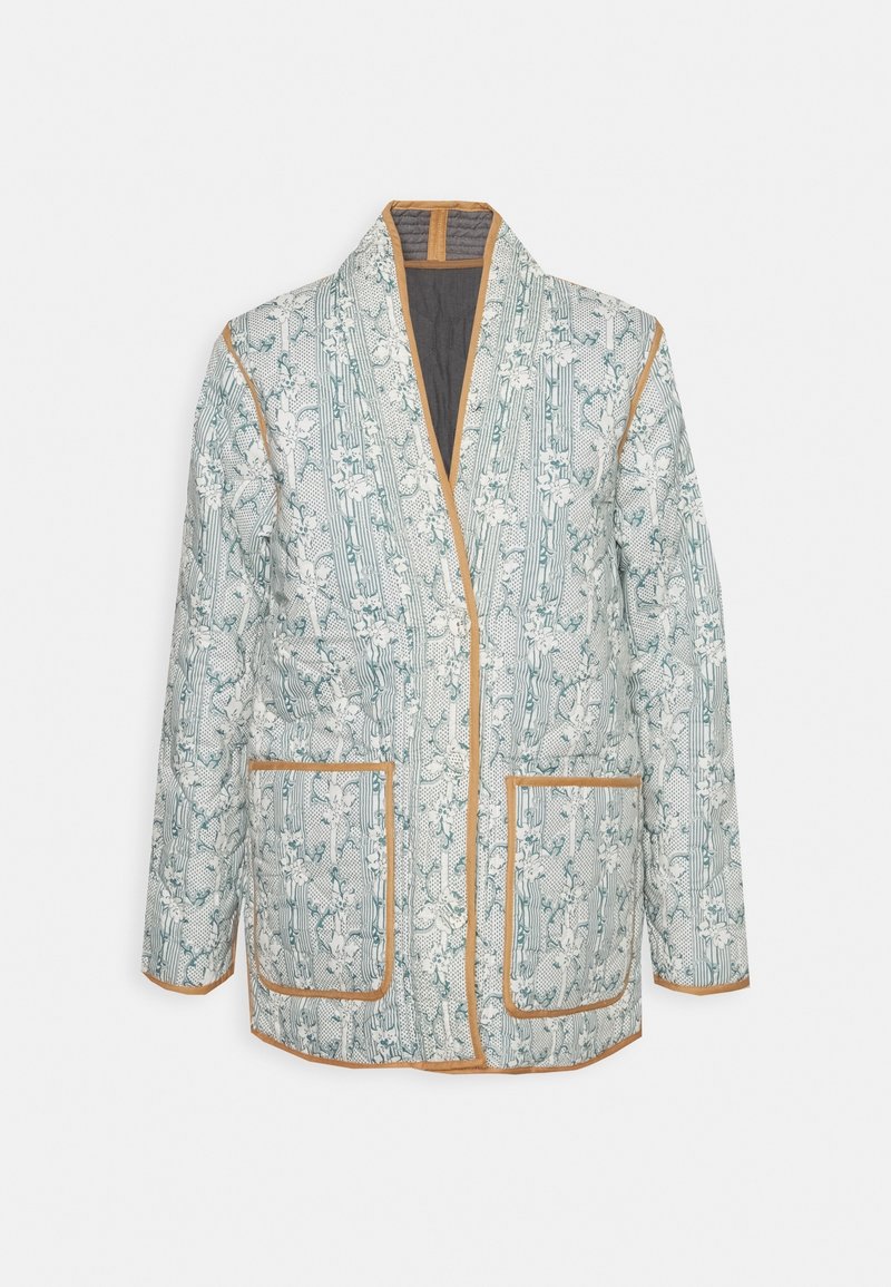 Veste matelassée avec motif floral et rayé, bordure beige, poches avant et col châle, présentée sur un fond uni.