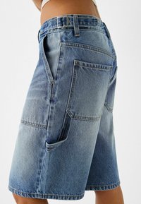 Leren spijkerbroek shorts in lichtblauw met een vervaagde wassingen. Bevat een gestructureerd ontwerp, grote achterzakken en een rechte pijp. Subtiele stikselaccenten.