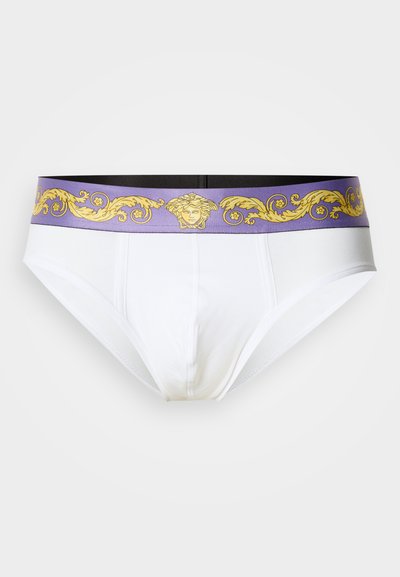 Λευκά εσώρουχα με μαύρη και μωβ ελαστική μέση που έχει χρυσό μοτίβο και σχέδιο κεφαλής Μέδουσας κατά μήκος του άνω άκρου.
