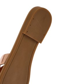 Suela de zapato de goma marrón con un acabado suave, puntera ligeramente redondeada y patrón de agarre texturizado con pequeñas ranuras para tracción.