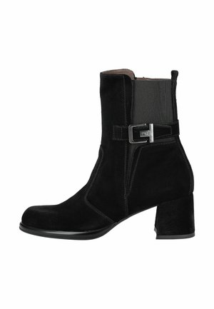 Stivale alla caviglia in suede nero con punta quadrata, pannelli laterali elasticizzati, tacco a blocco di altezza media e una fibbia argentata decorativa sul lato.