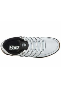 White athletic shoe with black accents and textured details. Features three white stripes, a padded collar, and a rubber sole.