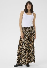 Jupe maxi avec une taille froncée, ornée d'un motif léopard dans des tons de noir, marron et crème, fabriquée à partir d'un tissu doux et léger.