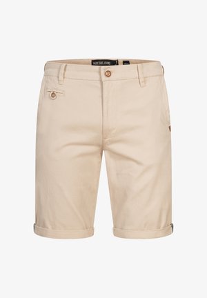 Beige bomullsshorts med rullet kant, med to frontlommer og knapplukking. Subtil tekstur og merkeetikett synlig.