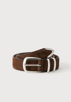Ceinture en daim marron enroulée avec une boucle rectangulaire argentée et deux passants argentés sur un fond clair.