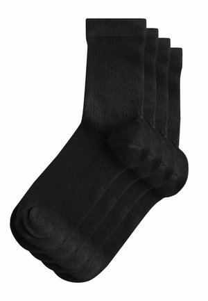 Vier Paare schlichte schwarze Socken in Crew-Länge, ordentlich mit leichtem Überlappen auf einem weißen Hintergrund gestapelt.