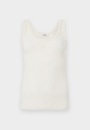 Ujjatlan krémszínű bordázott trikó mély kivágással, kis hímzett logóval a nyakkivágás alatt középen.