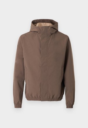 Giacca marrone con cappuccio, polsini ed orlo elasticizzati, chiusura frontale con zip e design semplice. L'interno ha un colore più chiaro a contrasto.