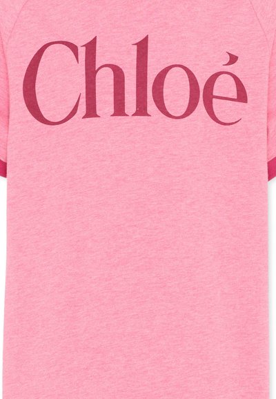Chemise rose à manches courtes avec des poignets rose foncé, comportant un grand texte "Chloé" rose foncé centré sur la poitrine.