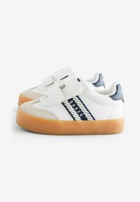 Valkoiset sneakerit, joissa on tummansiniset raidat, vahvistettu kärki, tarrasulkimet ja vaalea ruskea kumipohja. Pehmeä nahka, jossa on mokkanahkaiset yksityiskohdat.