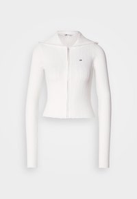 Maglione zip-up bianco a coste con maniche lunghe e colletto ripiegato. Presenta un piccolo logo sul lato sinistro del petto. Design cropped.