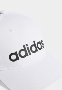 White baseball cap made of cotton, featuring a black "adidas" logo on the front, structured shape, and curved brim.