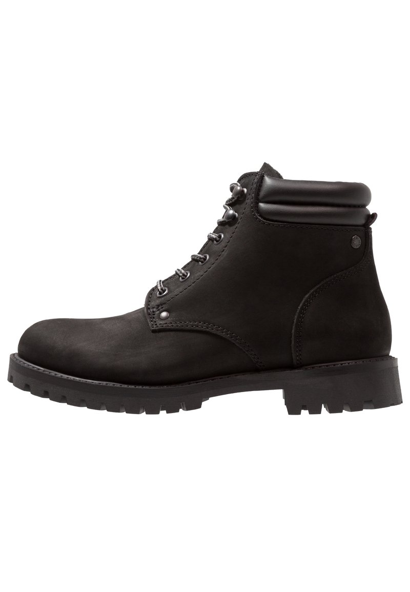 Černé semišové kotníkové boty s kulatou špičkou, stříbrnými očky, černými tkaničkami, polstrovaným límcem a hrubou gumovou podrážkou.