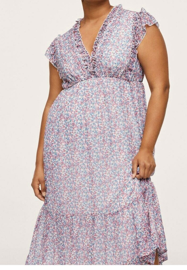 Kukkamekko, jossa on röyhelökaula-aukko ja hihat, joissa on vaaleanpunaisia, sinisiä ja valkoisia kuvioita, kerroksellinen helma ja läpikuultava kangastekstuuri.