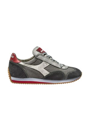 Zapatilla deportiva gris con materiales de ante y tela. Presenta un logo blanco, acentos rojos, cordones grises y una suela de goma con patrón.