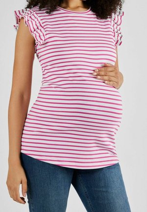 Pregnant person wearing pink and white striped ruffle-sleeve top and blue jeans, with hand resting on the belly.
