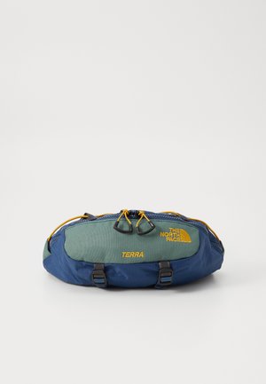 Modrá a zelená ledvinka s texturovaným povrchem. Obsahuje žluté akcenty, nastavitelné popruhy, zipové uzávěr a značku "TERRA".