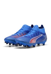 Un paio di scarpini da calcio alti blu con accenti arancioni e bianchi e tacchetti moldati su uno sfondo bianco.