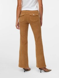 Brązowe spodni flared z korka o teksturowanej tkaninie. Posiadają dwie tylne kieszenie i błyszczące srebrne guziki. W zestawie z czubkami na obcasie.