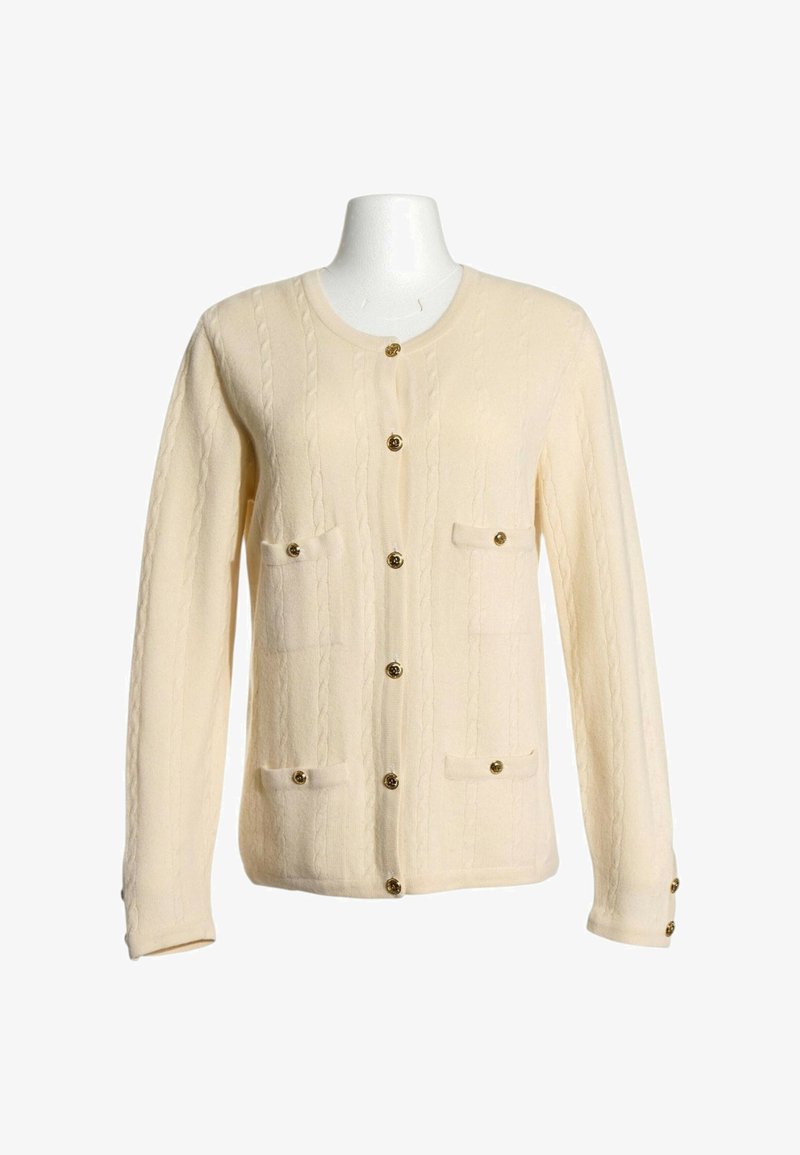 Cardigan tricoté de couleur crème avec manches longues, sept boutons dorés sur le devant et quatre petites poches avec rabats boutonnés.