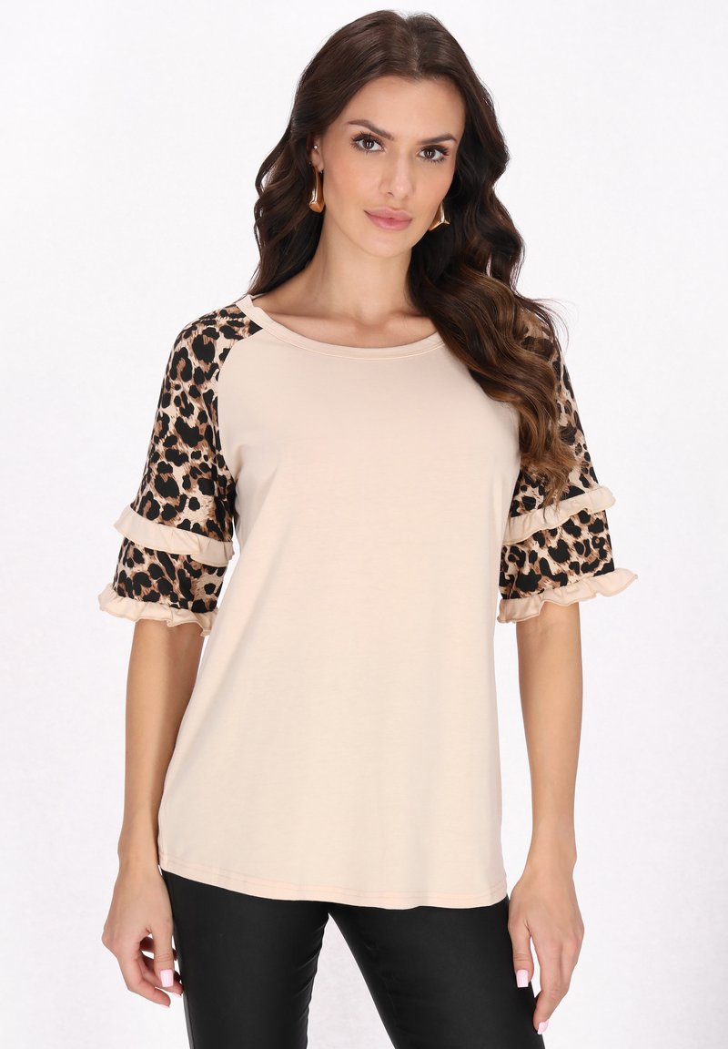 Beige top s krátkými leopardími rukávy a volánkovými detaily, vyrobený z měkké látky. Má kulatý výstřih a uvolněný střih.