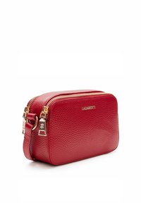 Rote, strukturierte Lederkosmetiktasche mit einem goldenen Reißverschluss und Beschlägen, rechteckiger Form und einem kurzen, abnehmbaren Trageriemen.