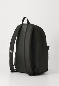 Schwarzer Rucksack aus glattem, gepolstertem Stoff; runde Form, doppelte Tragegurte, seitliche Reißverschlusstasche und kleiner Logoakzent.