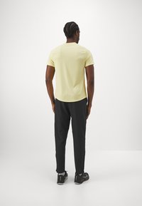 Nike Performance TOP - Camiseta deportiva - soft yellow/topaz gold/black