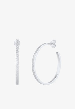 Sølv hoop øreringe med en struktureret overflade og glat indre kant, der har en sommerfuglsklip og er stemplet med "925."