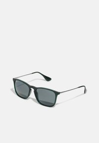 Occhiali da sole verdi in plastica con lenti grigio scuro, forma rettangolare e braccia metalliche sottili. Presentano un logo discreto su una lente.