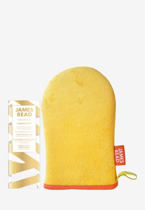 Felgele tanning handschoen met oranje rand en lus, naast een gouden en witte doos met het label James Read Enhance Tanning Mitt.