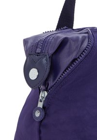 Lila Nylon-Tasche mit glatter Textur, ausgestattet mit einem oberen Reißverschluss, einem Leder-Zipper und silberfarbenen Beschlägen.