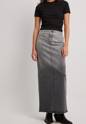 Svart T-shirt som matchas med en högmidjad, ankellång, grå denimkjol med en blekt finish och synliga sömnadsdetaljer.