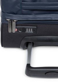 Marineblauer Softshell-Koffer mit Doppelreißverschlüssen, Zahlenschloss und ausziehbarem Griff aus silbernem Metall und schwarzem Kunststoff.