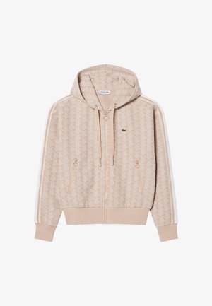 Beige hoodie met ritssluiting, geometrisch patroon, zijzakken, capuchon met trekkoord en witte strepen op de mouwen, met een klein groen krokodillenlogo op de borst.