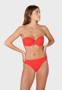 Red bikini set featuring a strapless top with molded cups and a matching high-waisted bottom. Smooth, stretchy fabric.