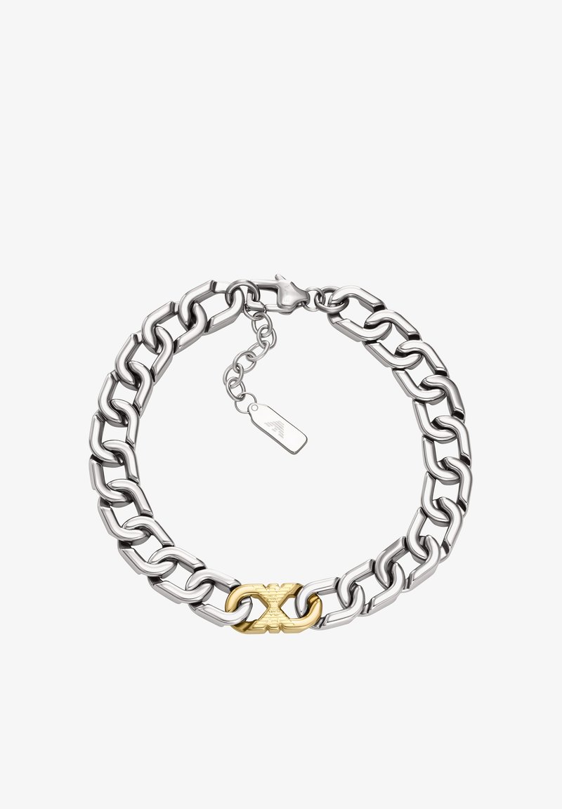 Hopeinen ketjurannekoru, jossa on toisiinsa lukittuvat lenkit, keskellä kultainen koriste ja kiinnitetty pieni metallinen nimilaatta.