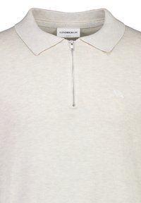 Ljus beige dragkedja polo skjorta med ribbad textur, smal passform och vikkrage. Har en liten logga på bröstet.