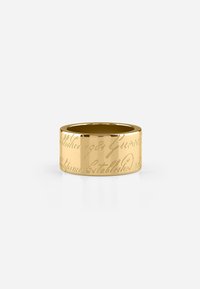 Bague en or avec un texte gravé dans un style cursif. Surface lisse et polie avec une forme cylindrique large.