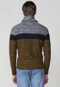 Gebreide trui met een hoge kraag, kleurblokken in grijs, marineblauw en mosterd, met een textuurafwerking en geribde zoom en manchetten.