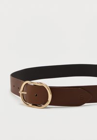 Hnedý kožený opasok s hladkou textúrou, ktorý má okrúhlu sponu v zlatom odtieni a viaceré dierky na nastavenie. Okraje sú pekne upravené.