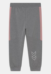 Pantalons de survêtement gris en tissu doux avec des panneaux latéraux roses, design à jambes fuselées et un motif chevron blanc sur la jambe inférieure. Taille élastique incluse.