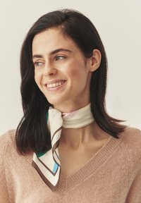 Siidist sall, millel on kreemikas taust ning geomeetriline muster roosa, sinise ja pruuni toonides, seotud lõdvalt kaela ümber.