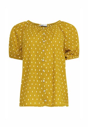 Geel kortärmelig blouse met witte rechthoekige stippen, ronde halslijn, knoopsluiting aan de voorkant en elastische manchetten.