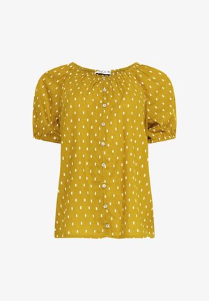 Geel kortärmelig blouse met witte rechthoekige stippen, ronde halslijn, knoopsluiting aan de voorkant en elastische manchetten.