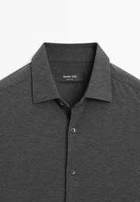 Dark gray short-sleeve polo shirt with a collar, featuring a buttoned placket and a soft, textured fabric. Label reads "Massimo Dutti."