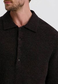 Dunkelgrauer Wollpullover mit Kragen, der eine strukturierte Oberfläche, einen Knopfverschluss und eine Mischung aus tiefen Brauntönen aufweist.